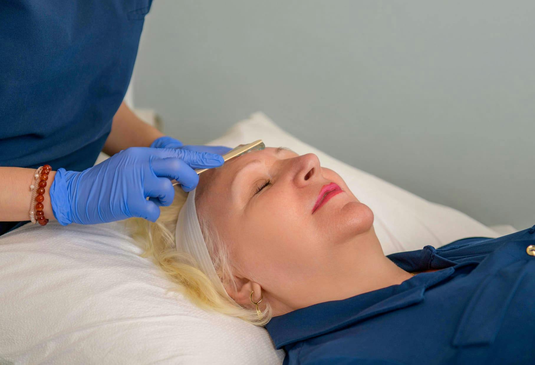 female patient laying down as she gets facial done