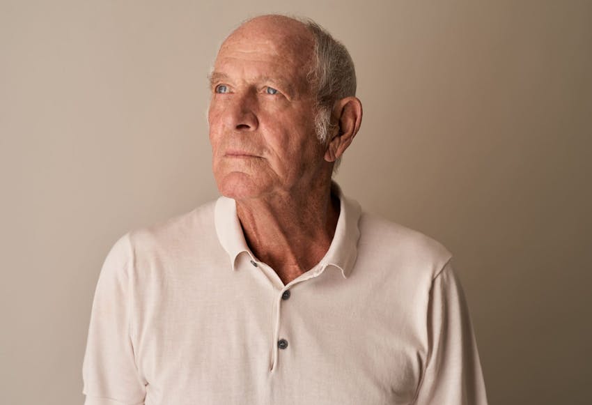 older man in white shirt looking to the left