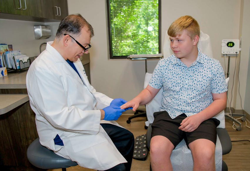 Abdul looking at male patient's hands