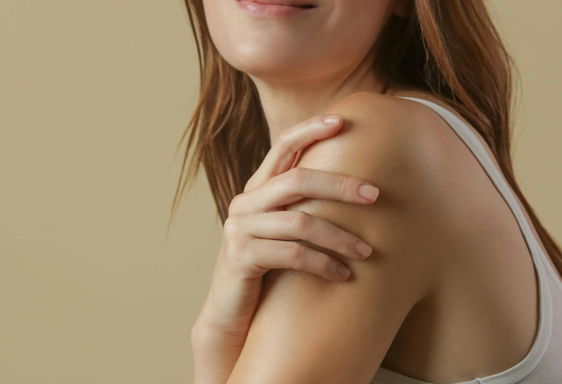 woman touching her shoulder and facing forward