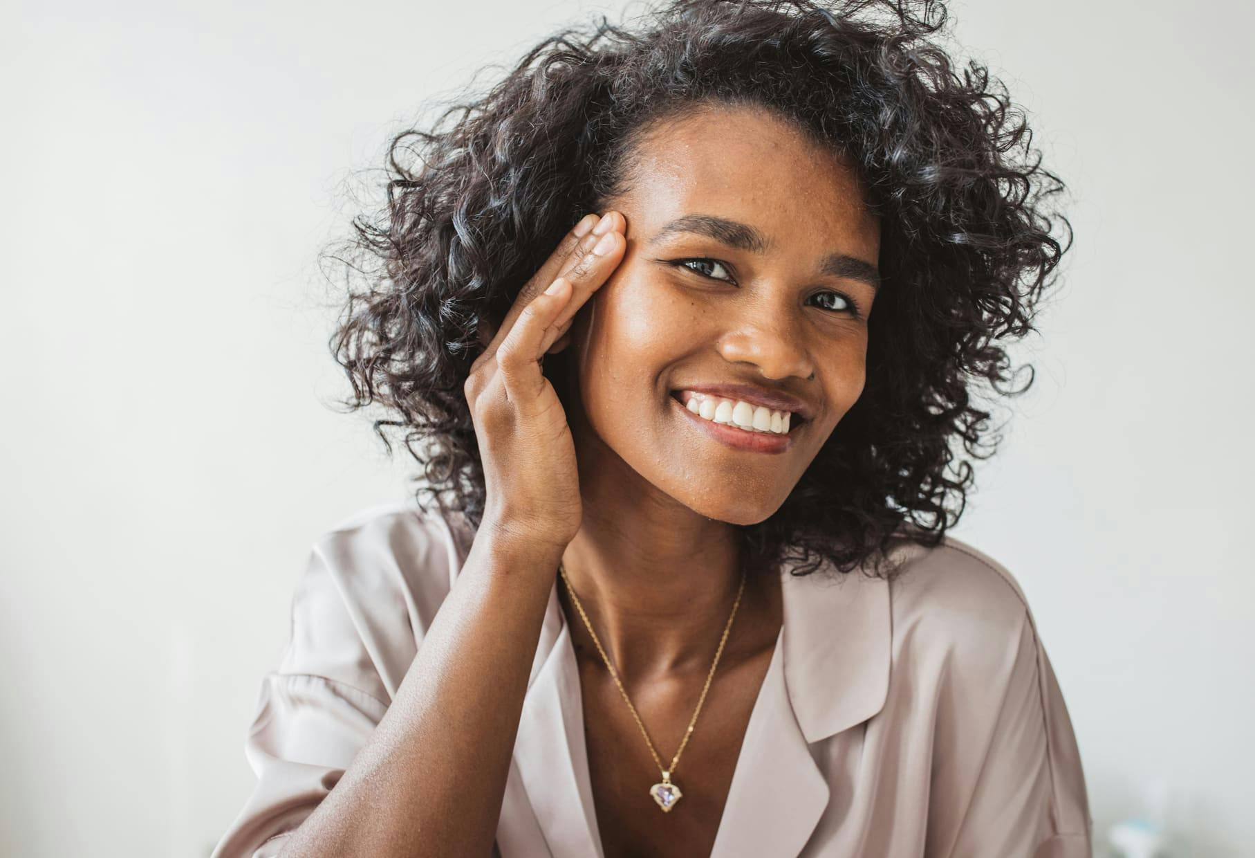 woman touching her temple and smiling