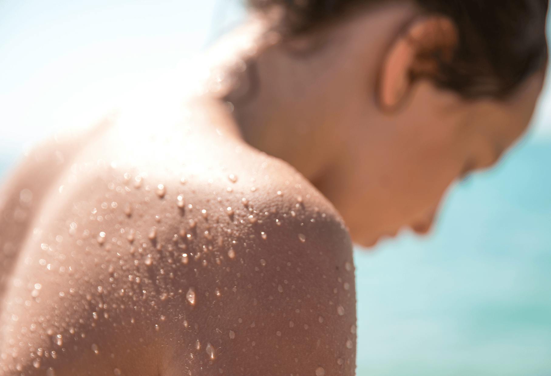 woman getting out of pool, close up on the water droplets on her back