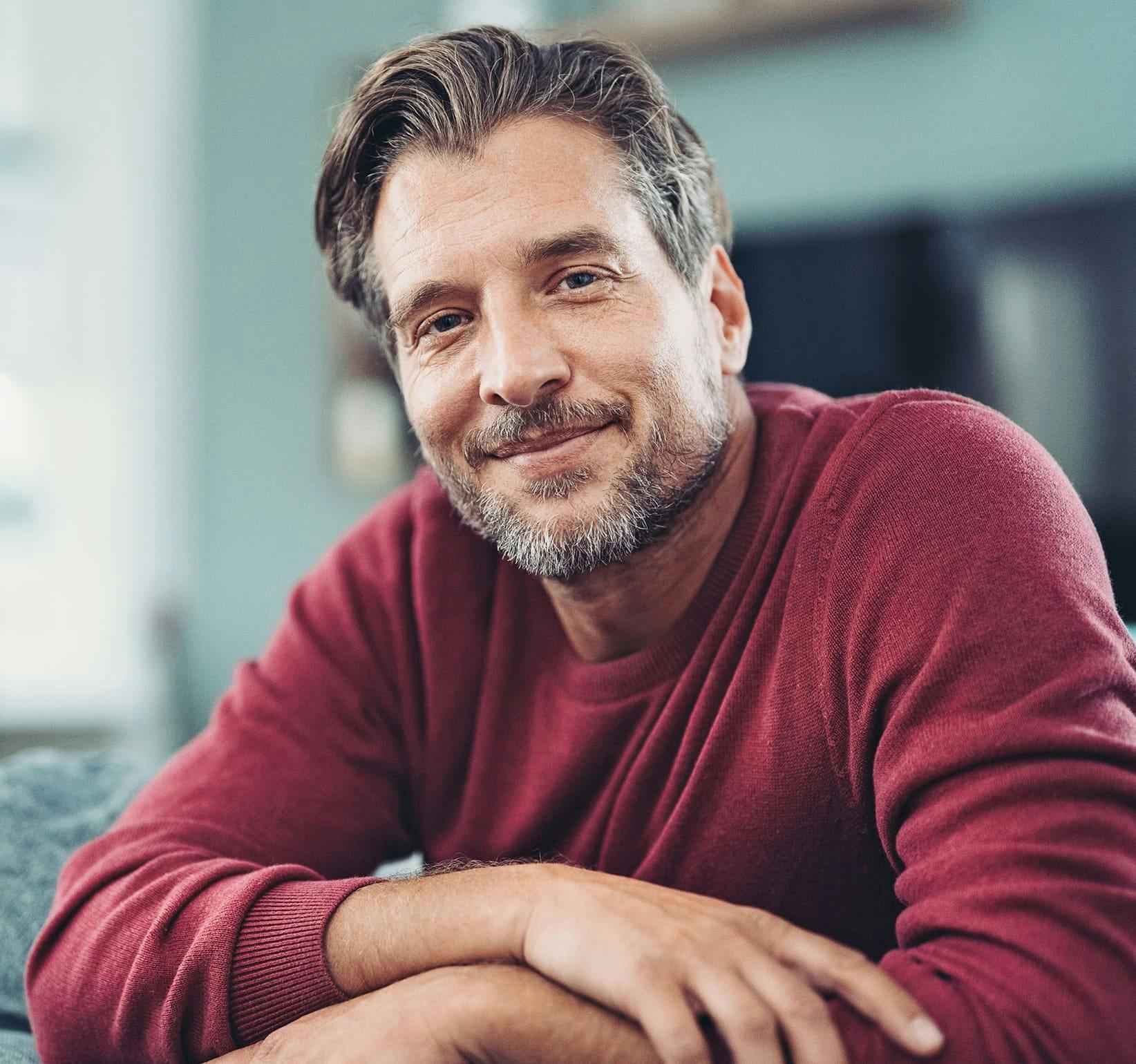 man in maroon sweater smiling