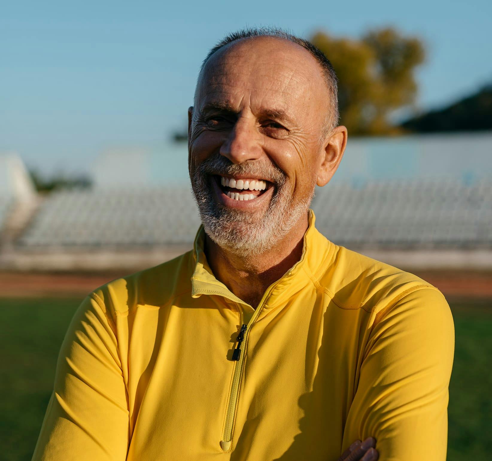 man smiling with yellow jacket on
