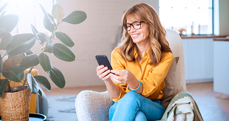 Woman in yellow shirt looking at phone