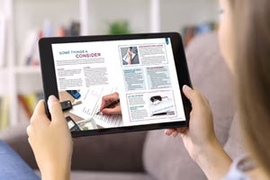 woman holding laptop looking at program