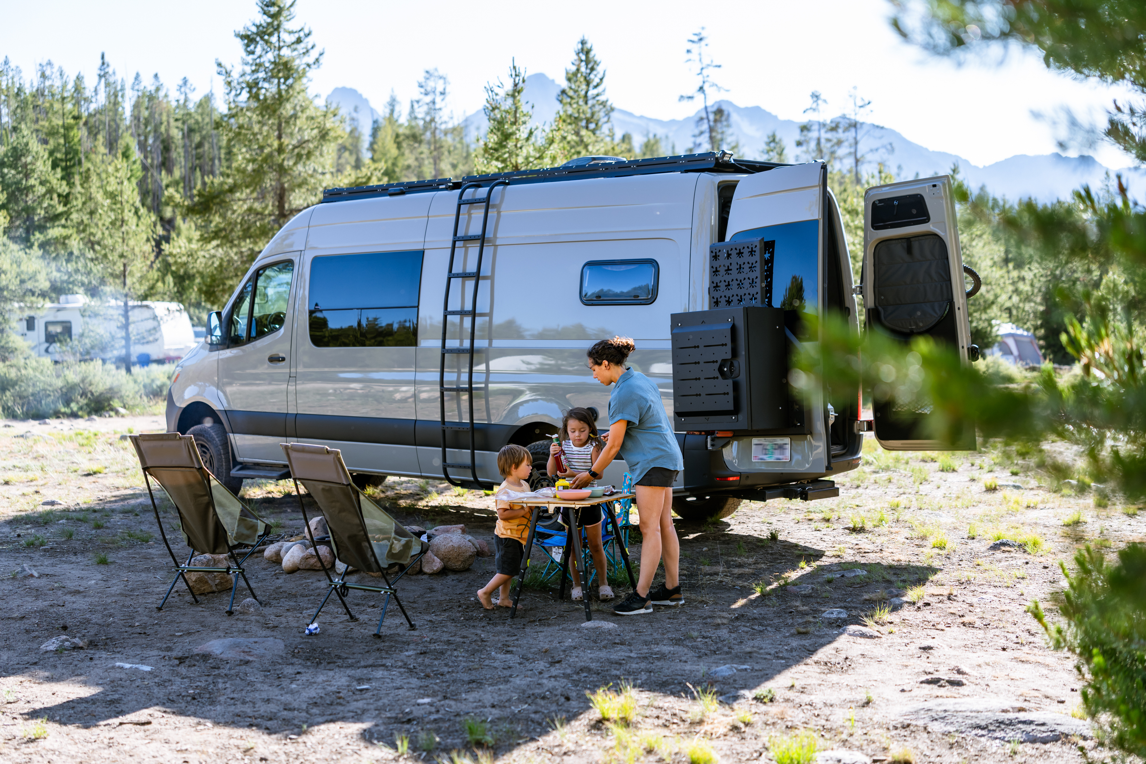 Mother with two children camping with a van.