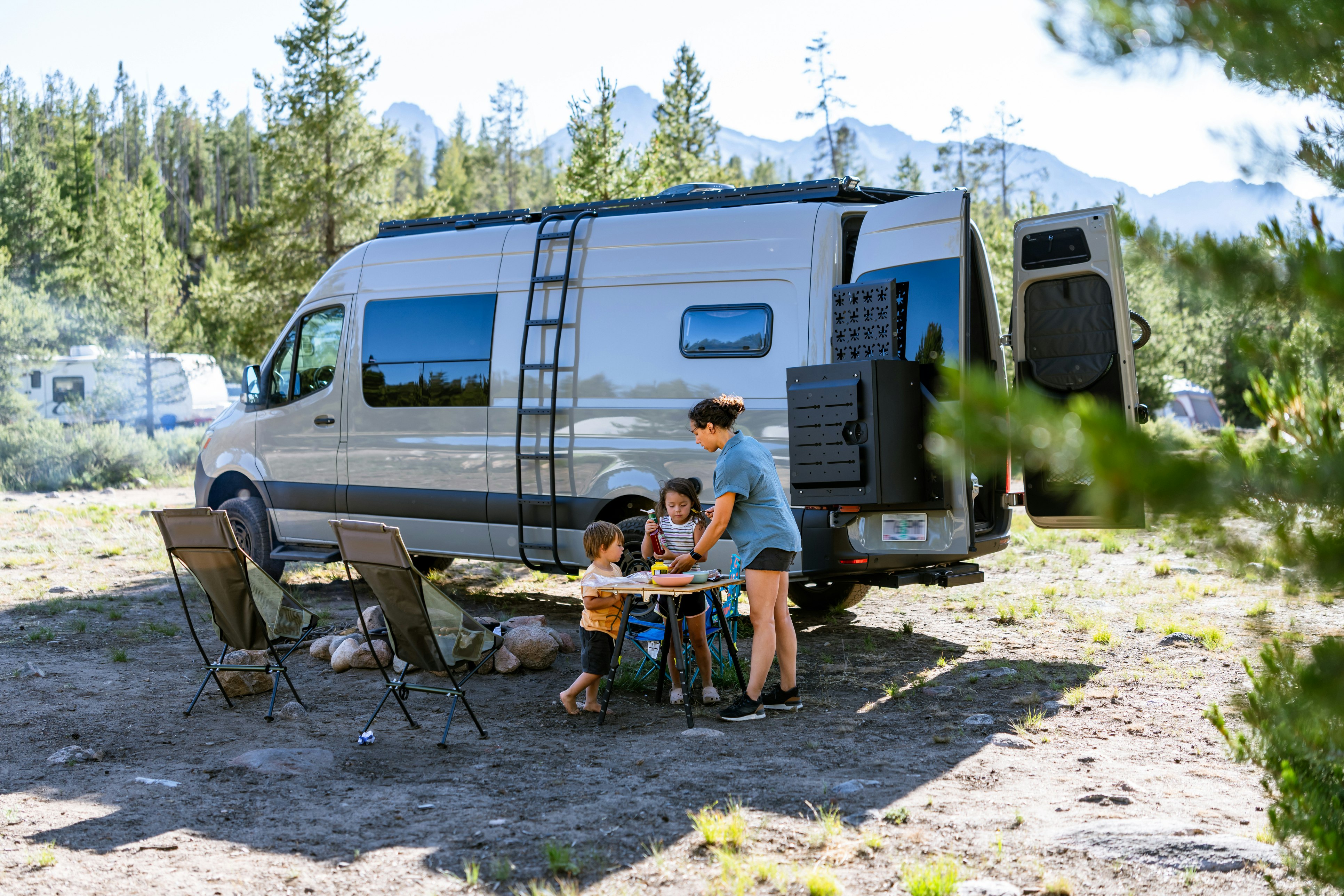Mother with two children camping with a van.