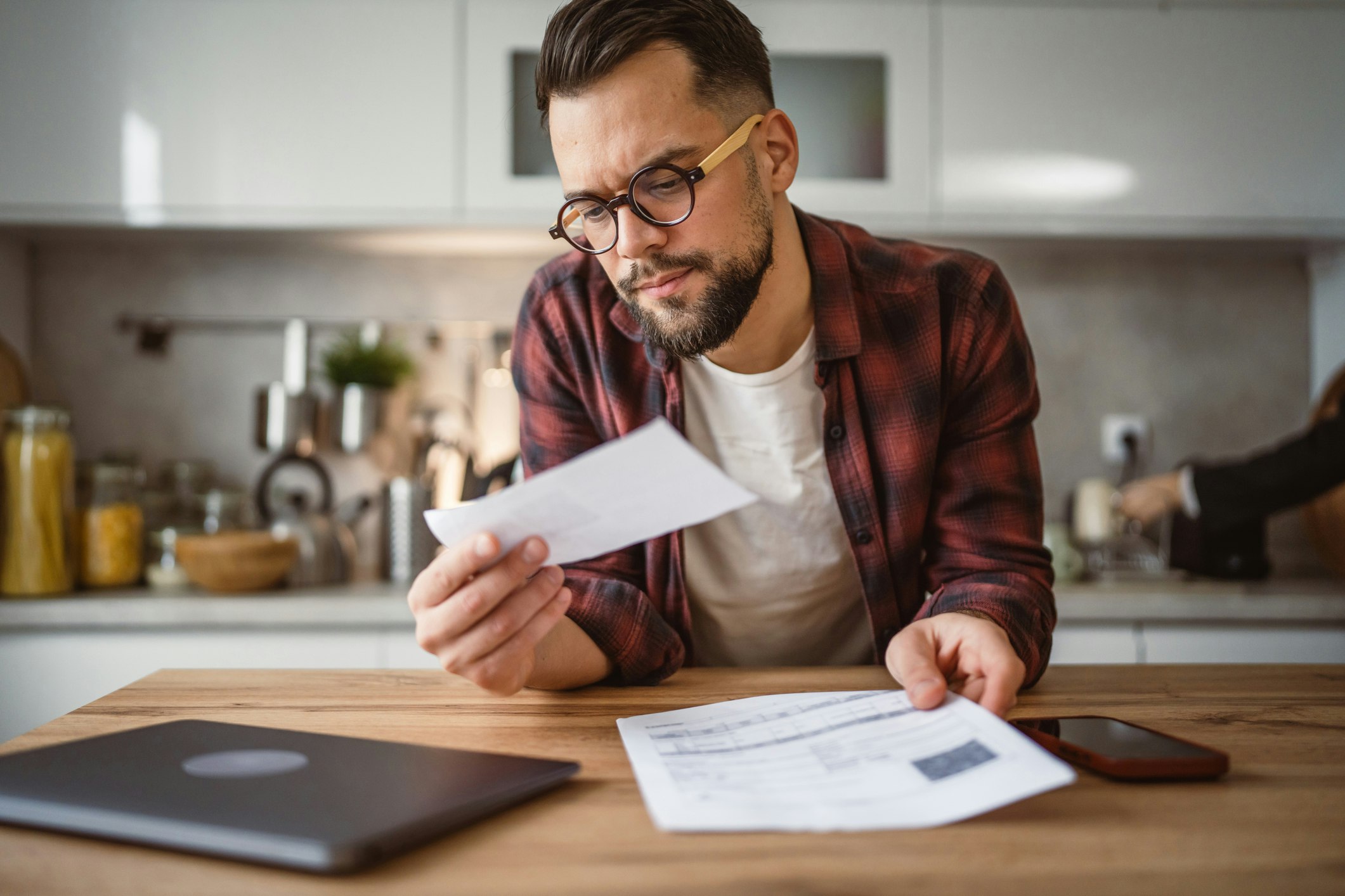 Adult man sit on sofa and have contactless payment bills on cellphone