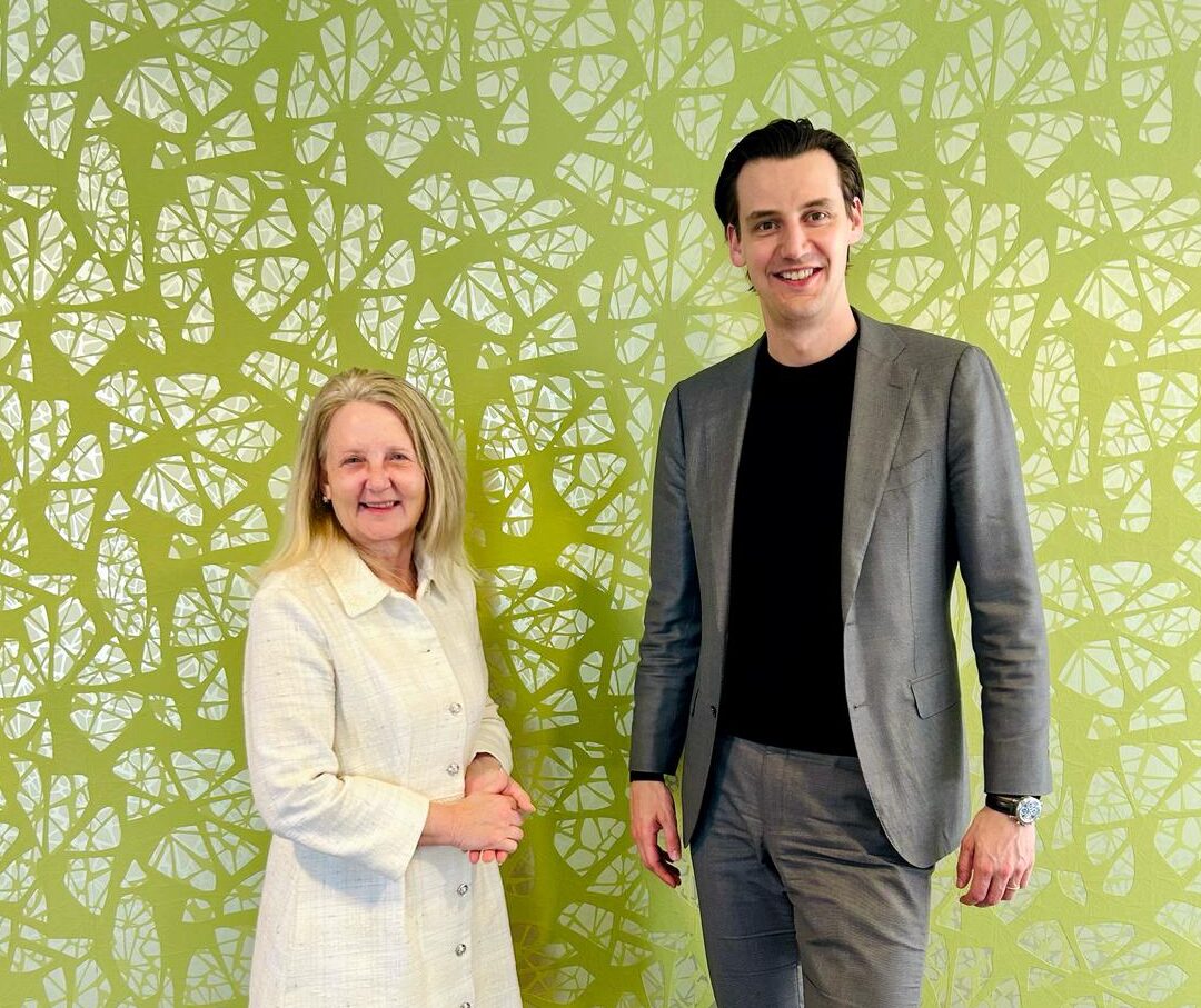 Twee personen staan naast elkaar en kijken in de camera.