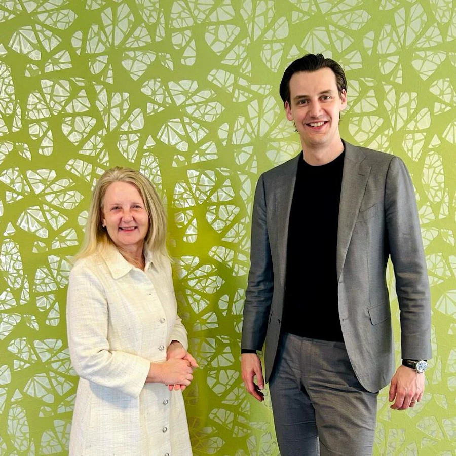 Twee personen staan naast elkaar en kijken in de camera.