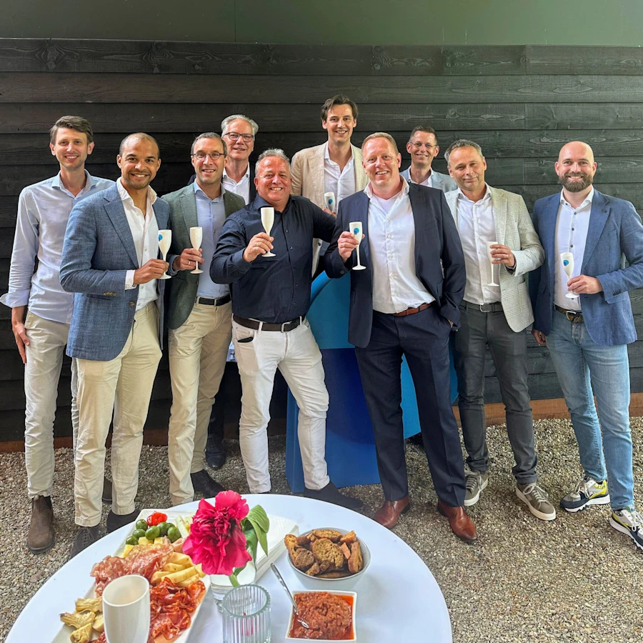 Groepsfoto waarop personen een glazen champagne vast hebben