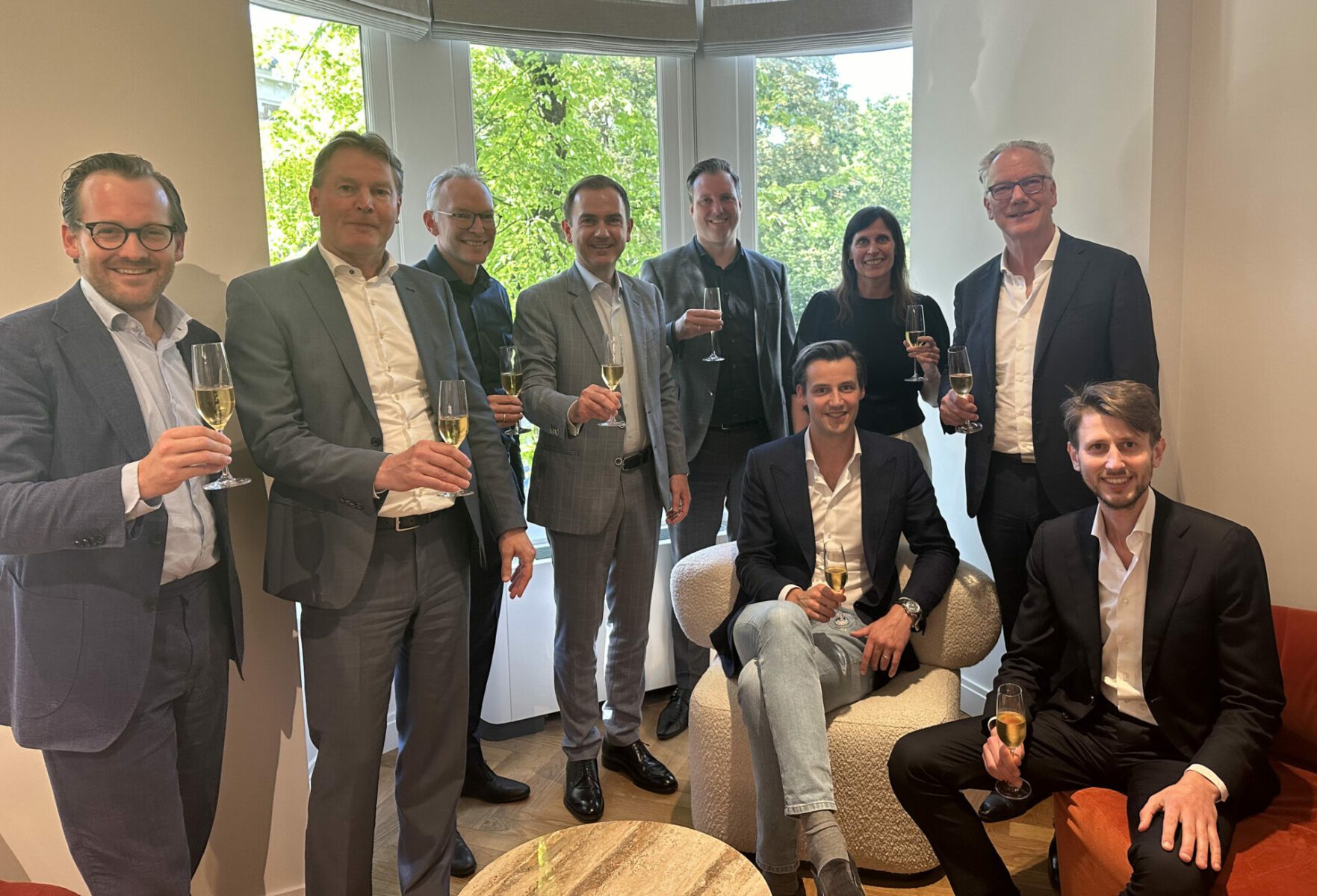 Dealfoto van PIA. Groep mensen met champagne in hun hand.