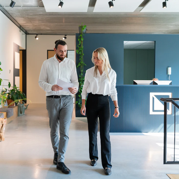 Twee personen lopen door het kantoor van Elysee.