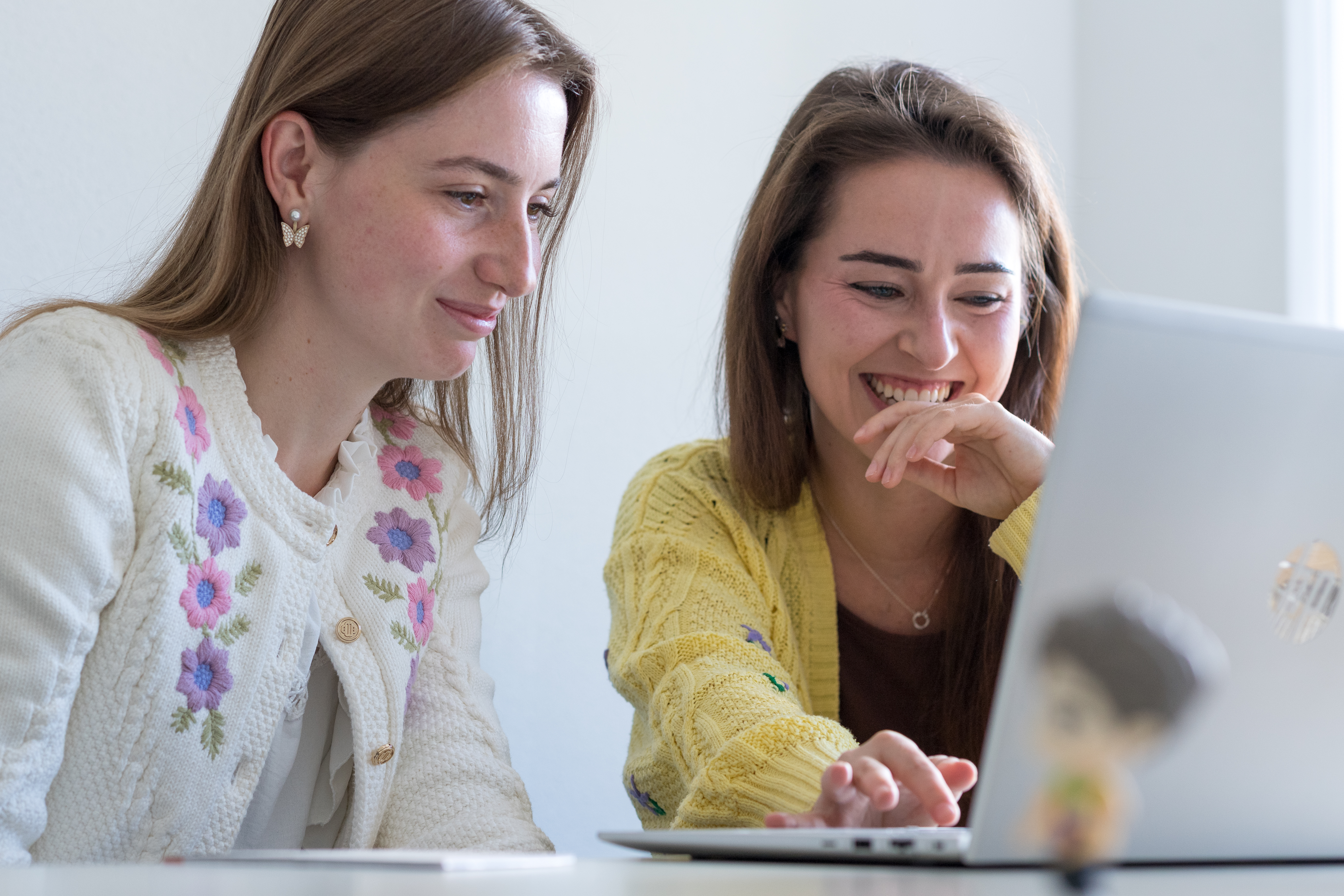 Twee personen achter een laptop, kijkend naar het scherm