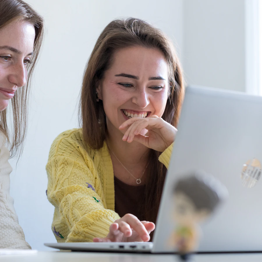Twee personen achter een laptop, kijkend naar het scherm