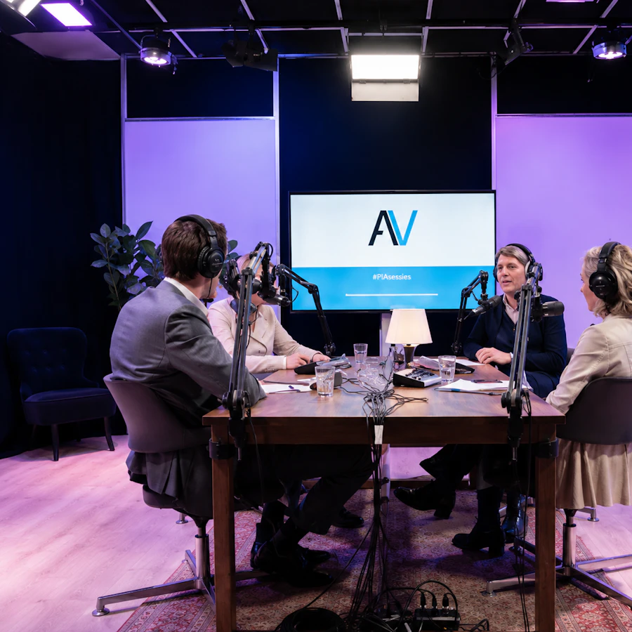 Podcast studio met vier mensen aan tafel tijdens de opname