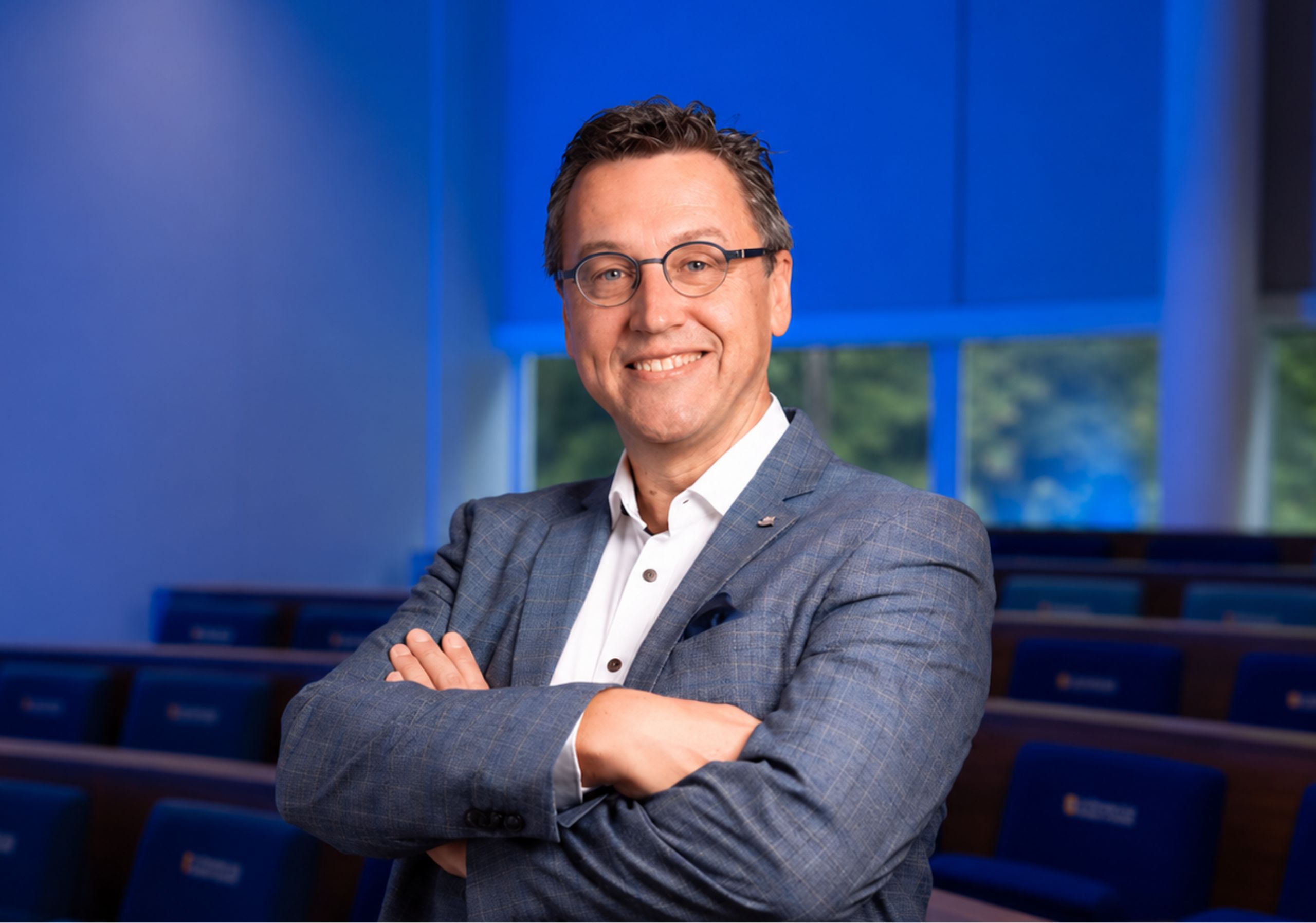 Man met gekruiste armen kijkt recht in de camera