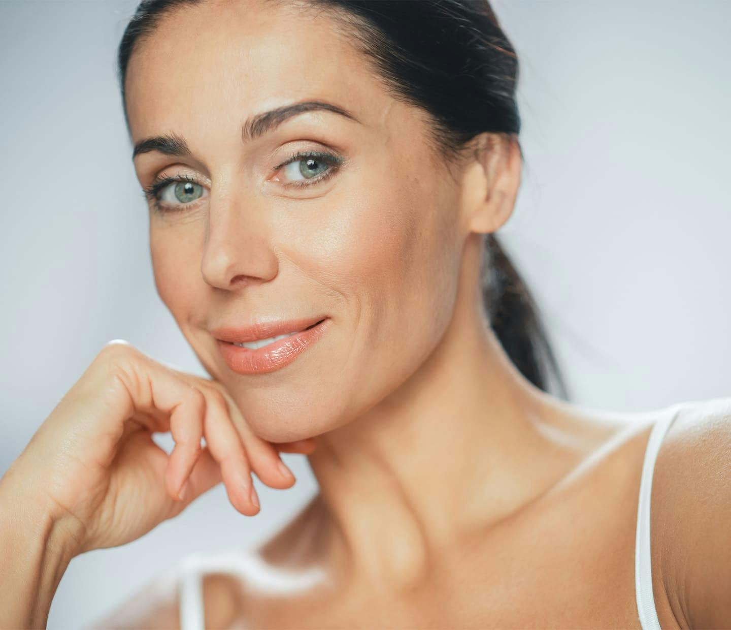 Woman smiling and touching chin