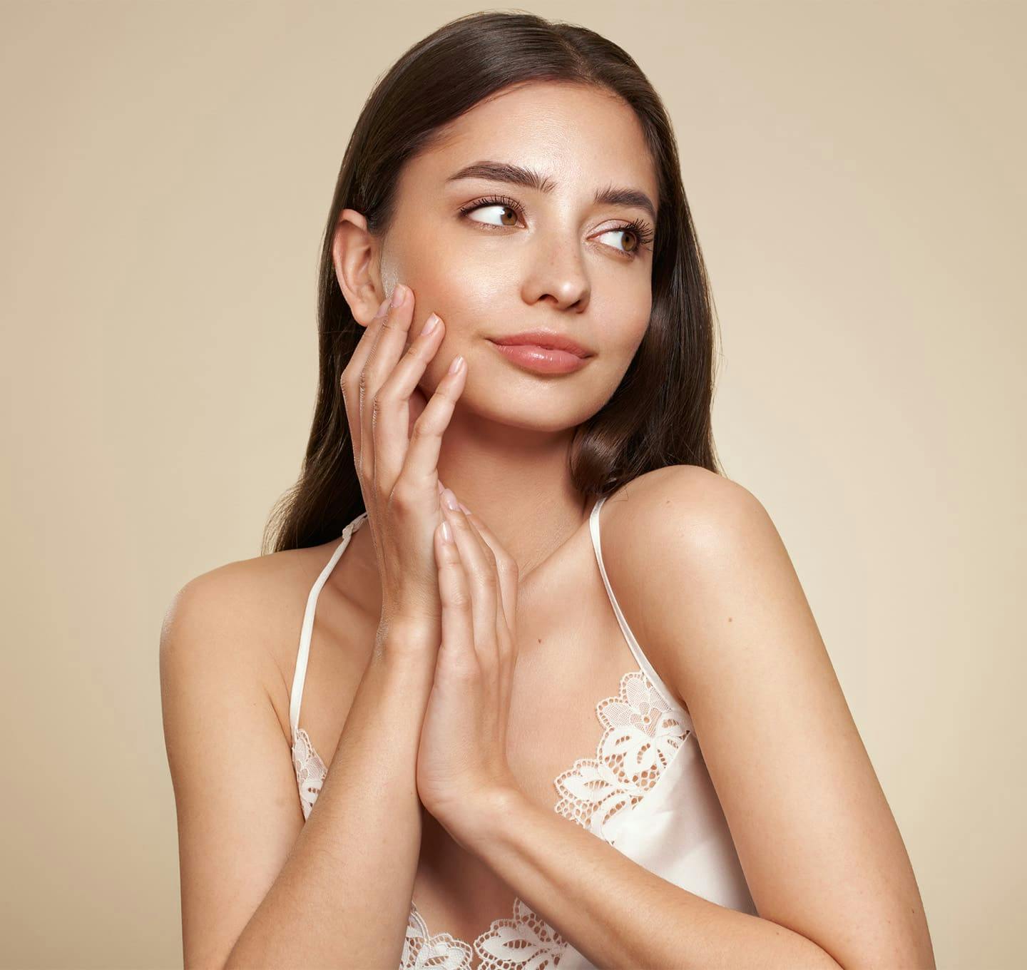 Woman smiling with hands on face