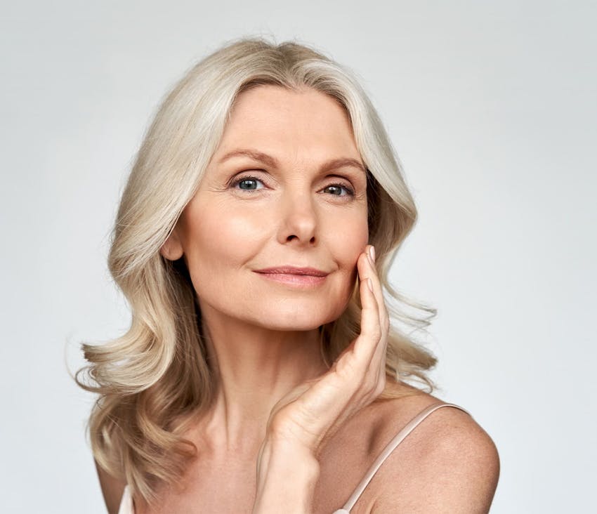 Woman smiling and touching face