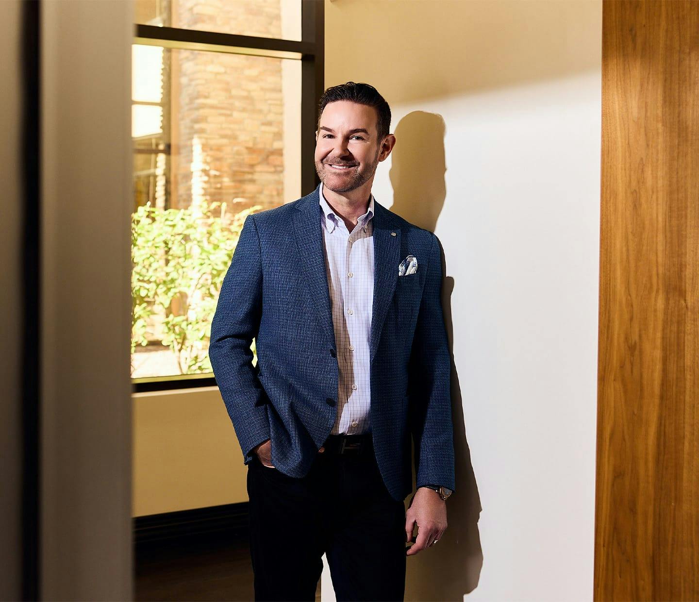 Doctor standing by a window smiling