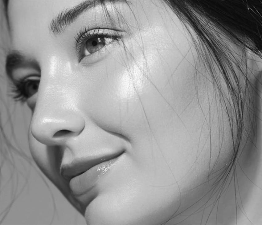 Woman smiling and touching her face