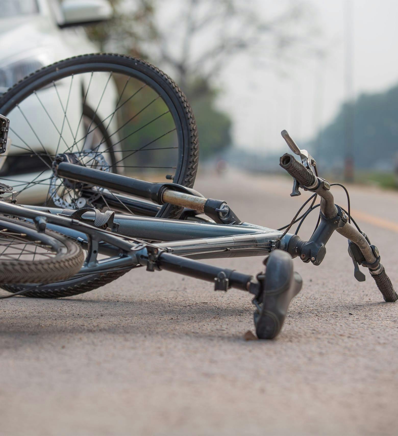 bicycle on the ground bext to a car
