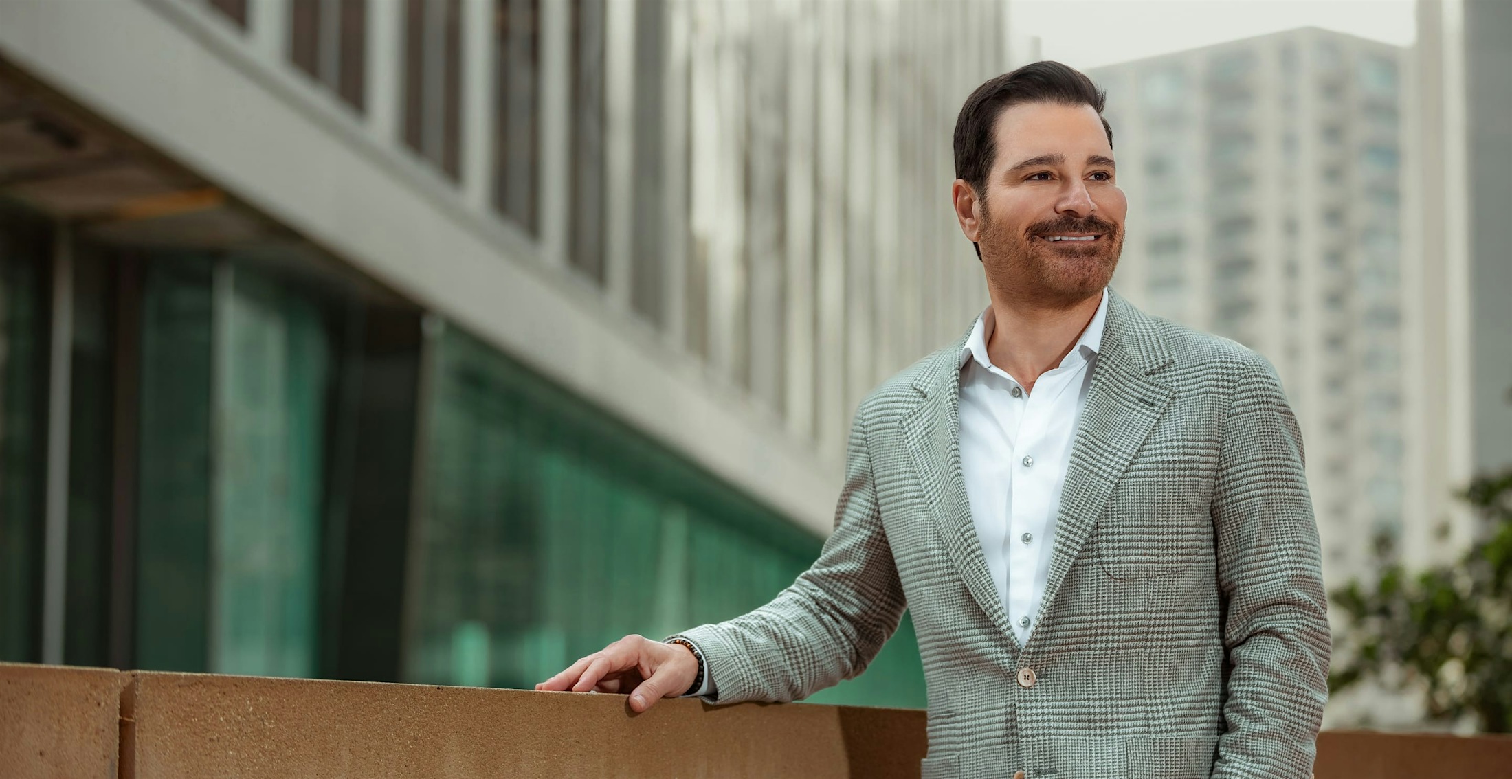Dr. Vartanian in a suit by a low wall