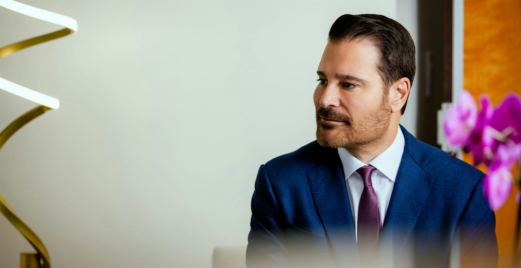 Dr. Vartanian in a suit in front of flowers