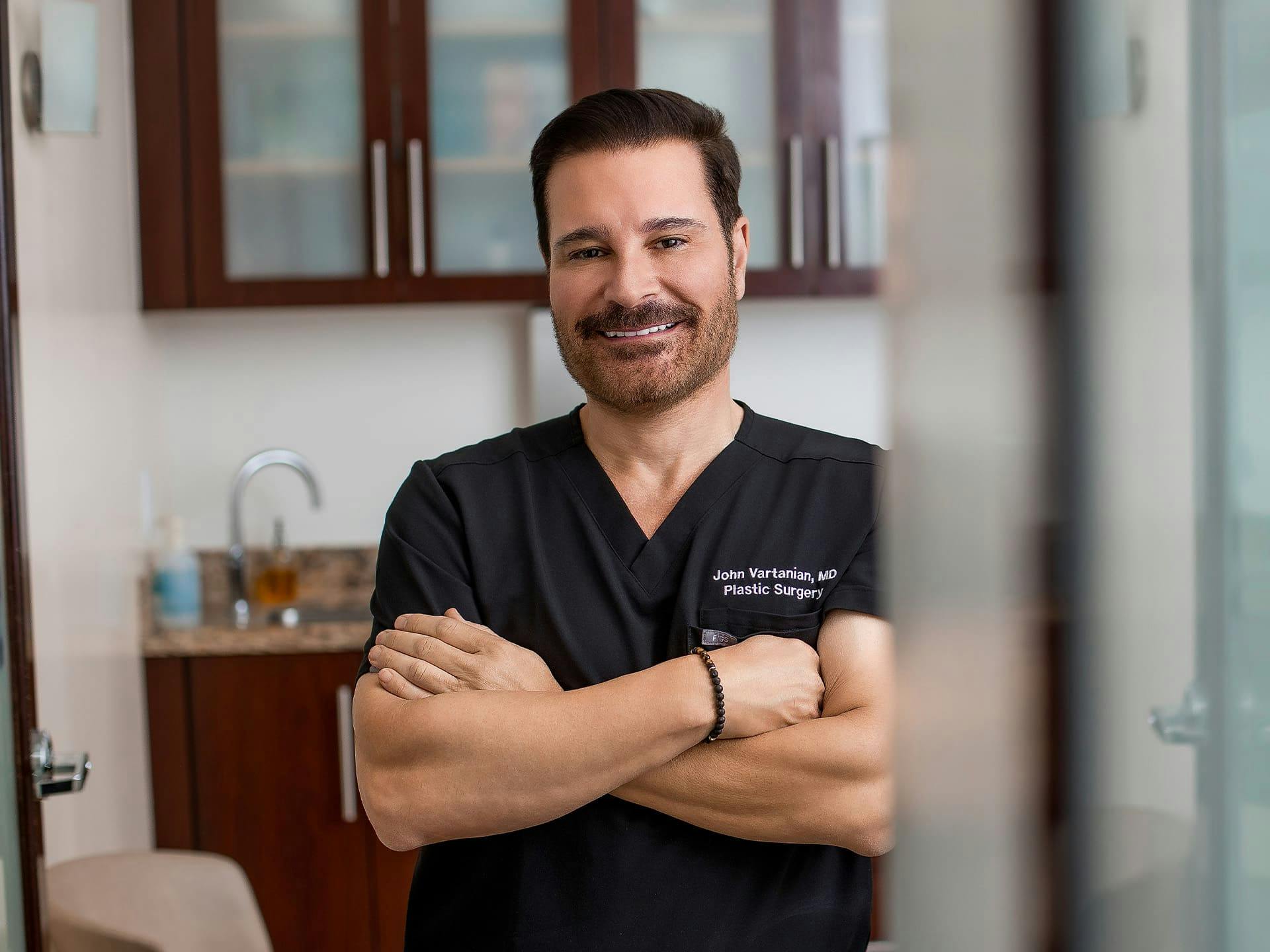 Dr. John Vartanian smiling with his arms crossed