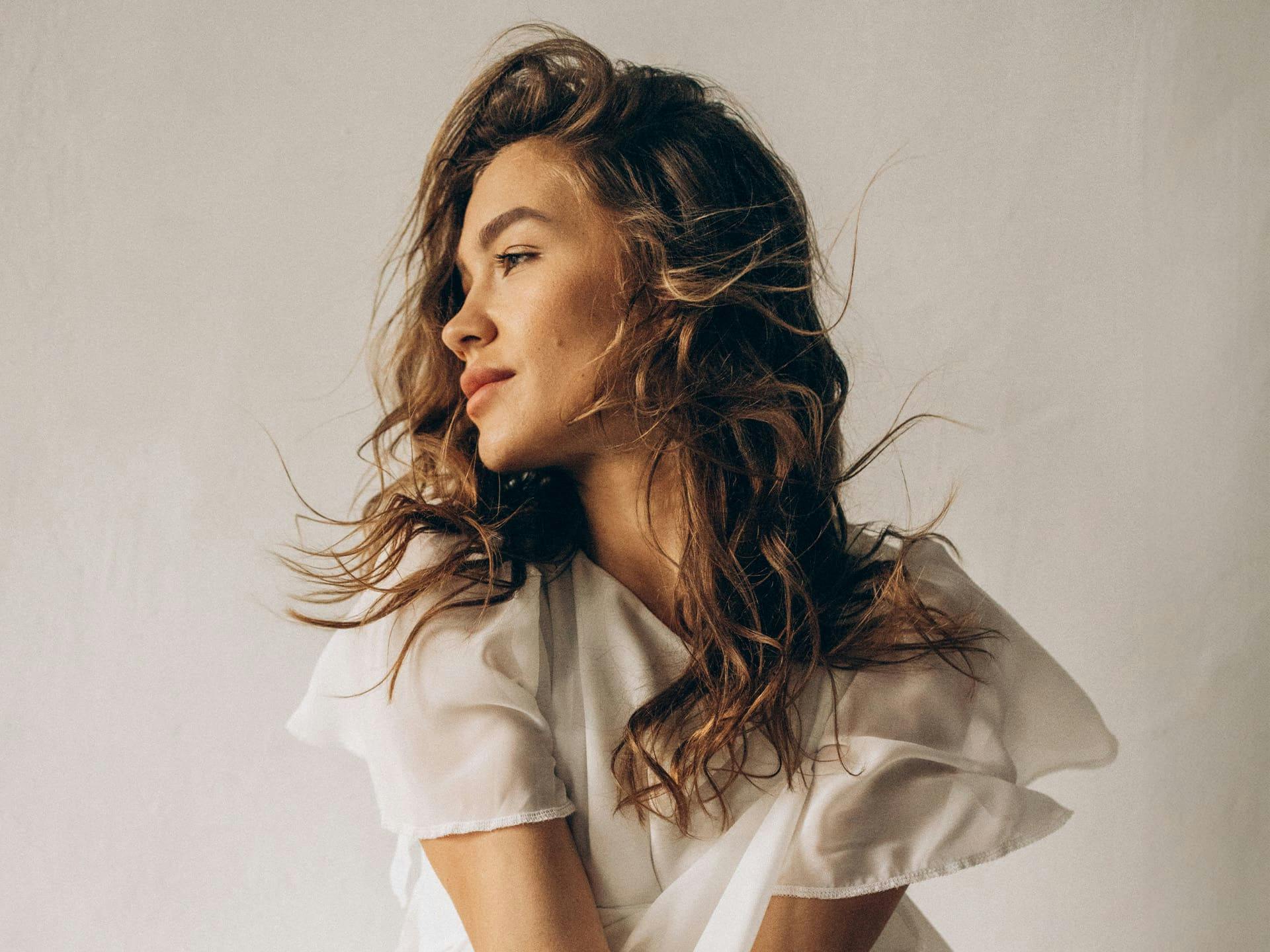 woman looking to the left with her hair getting hit with wind