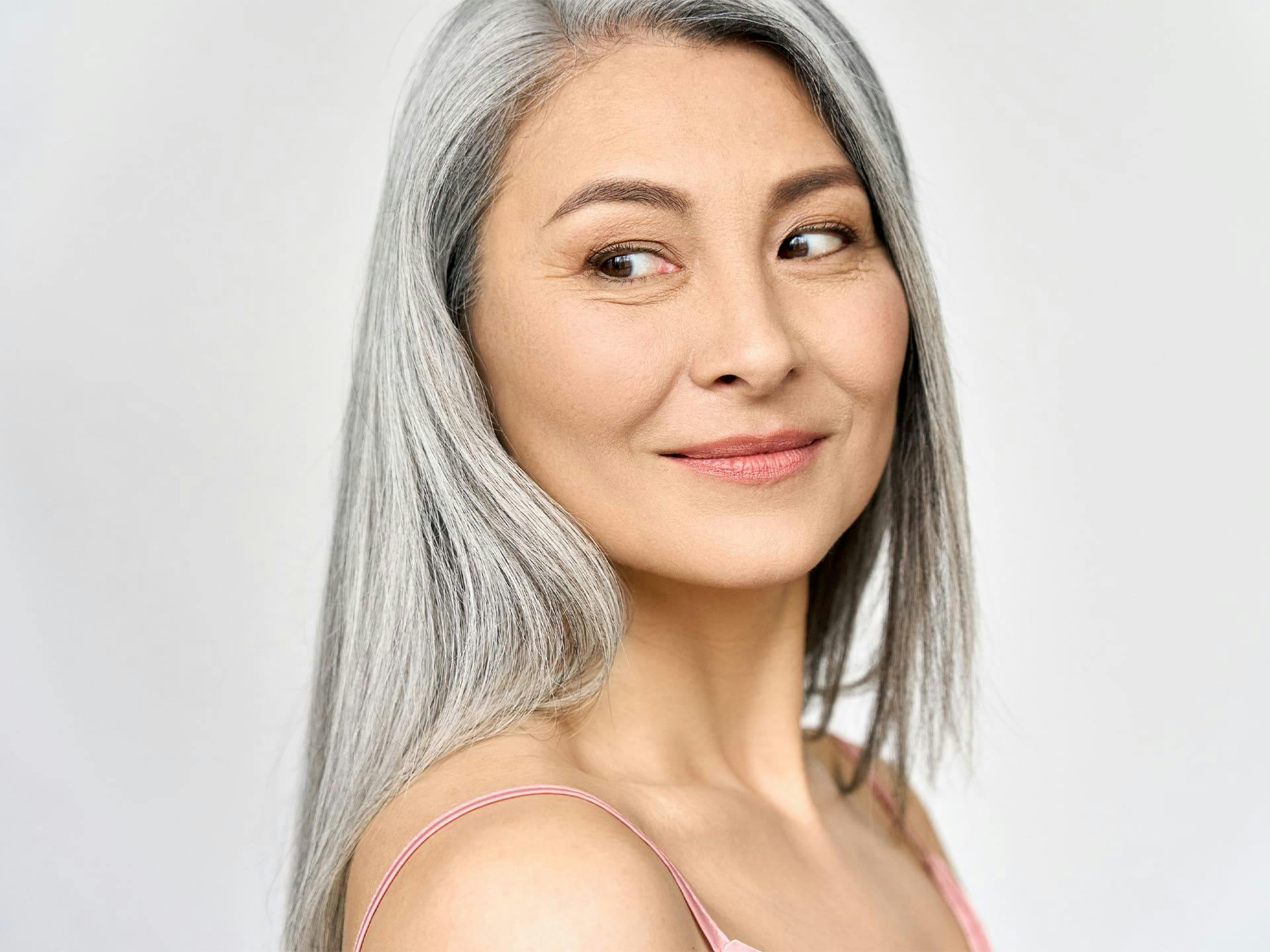 woman with gray hair smiling and looking to the side