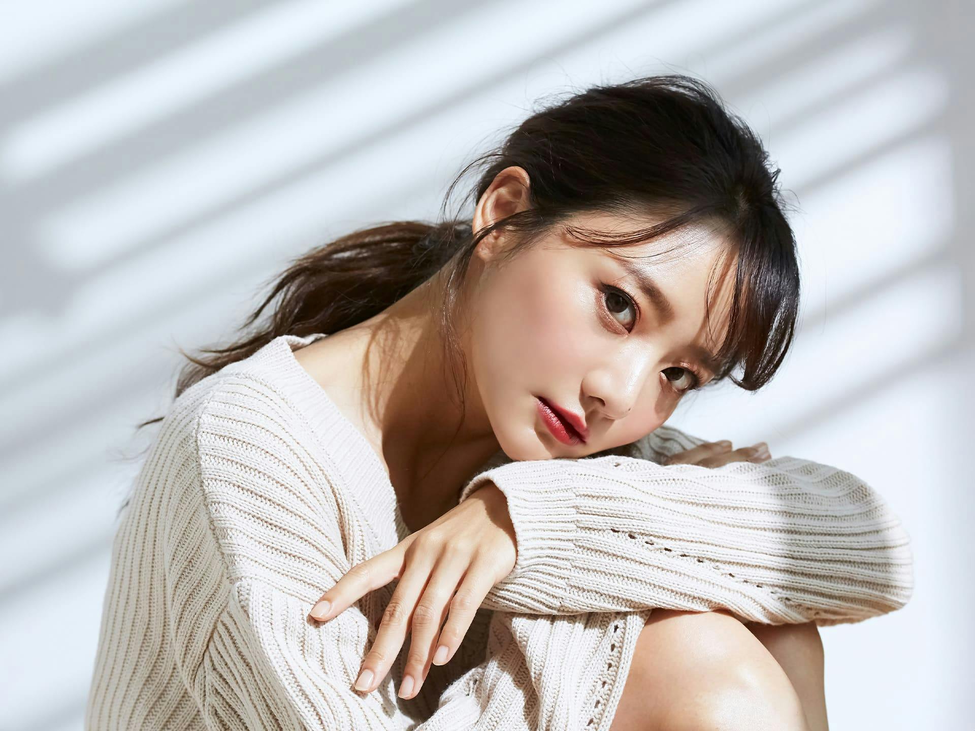 asian woman with her arms and head tucked into her knees