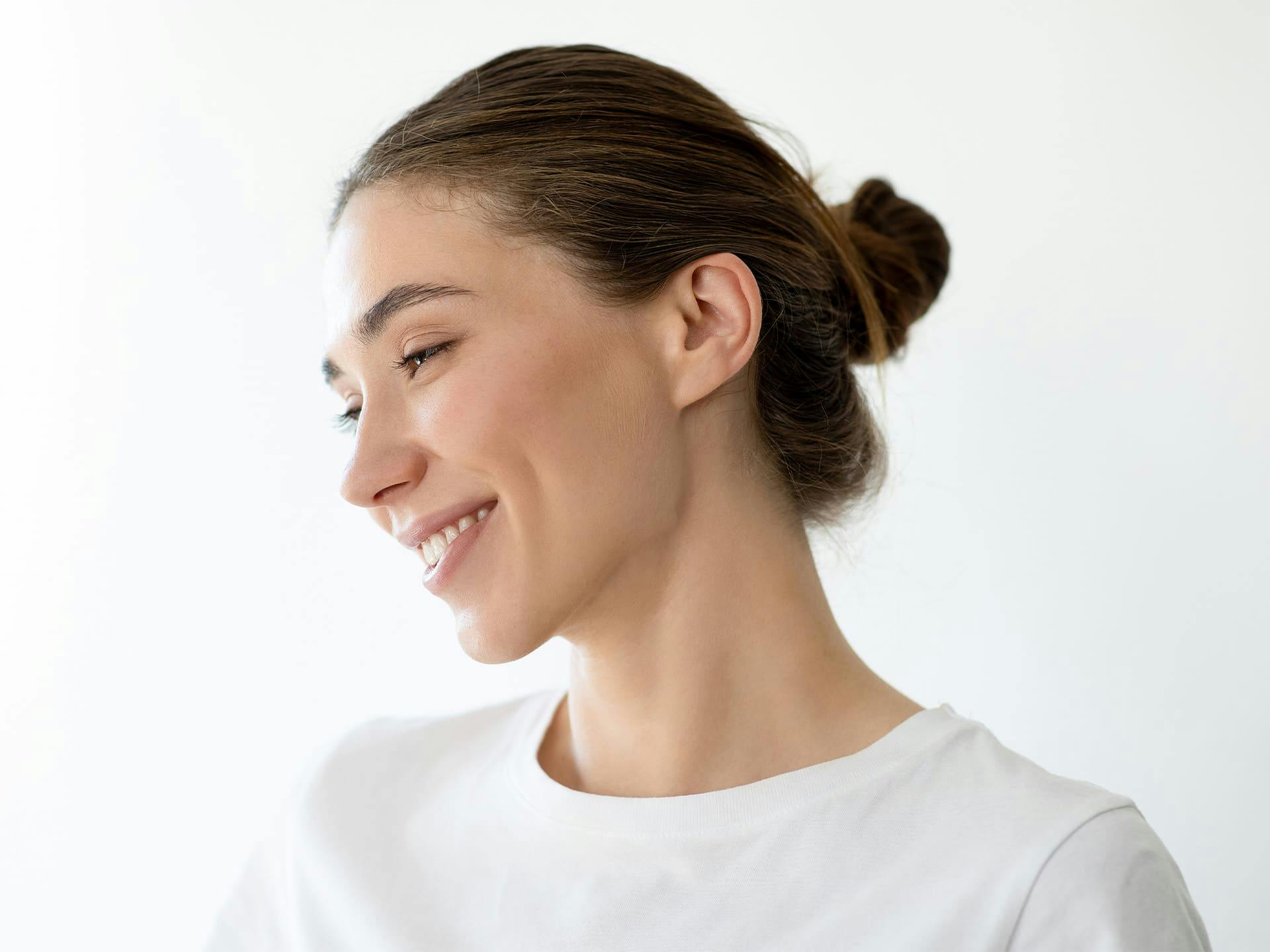 woman facing to the side with her hair tied into a low bun