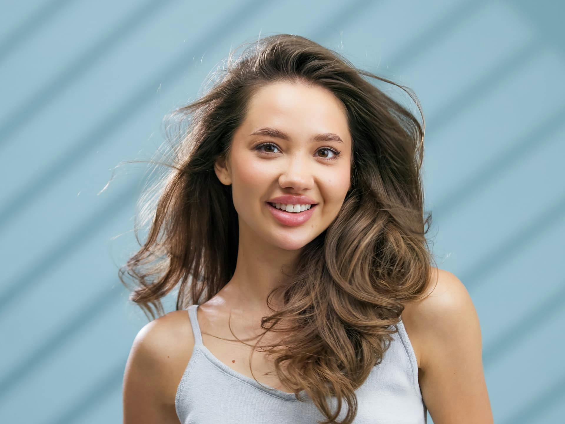 woman smiling with her fluffed hair in the wind