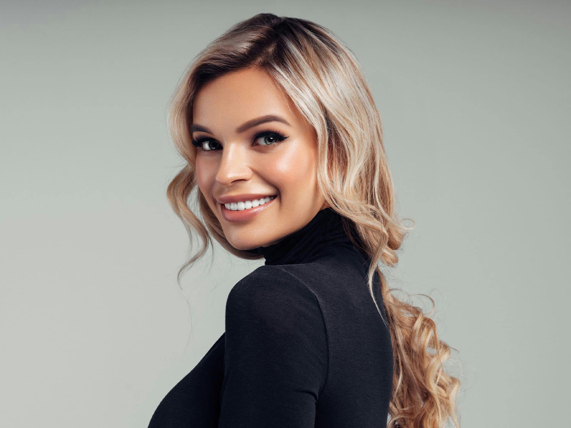 woman with long blonde hair while wearing a turtle neck