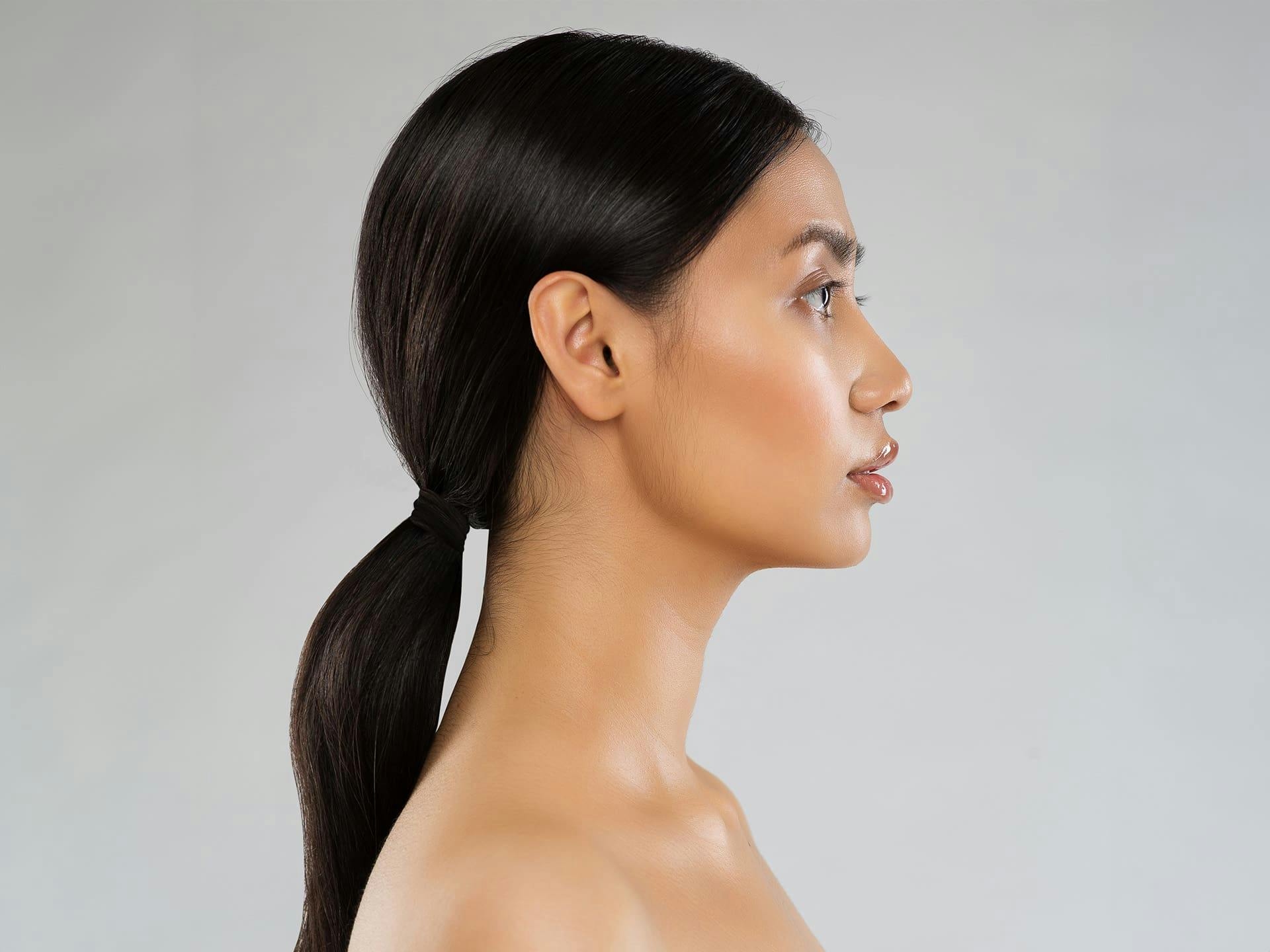 side profile of woman with low ponytail facing the right