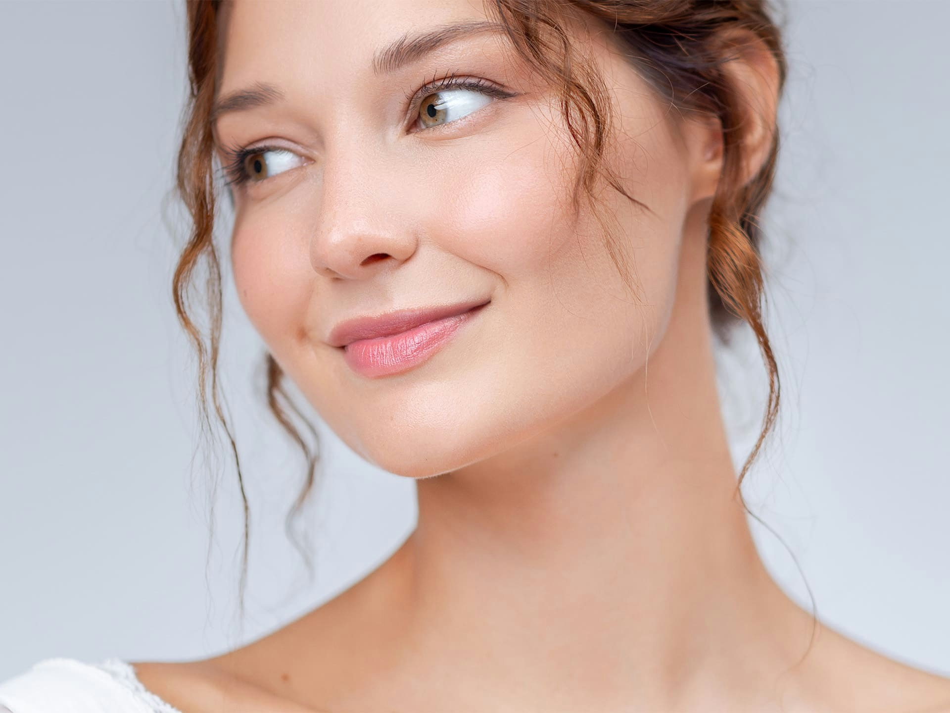 woman with wavy hair smiling and looking to the left