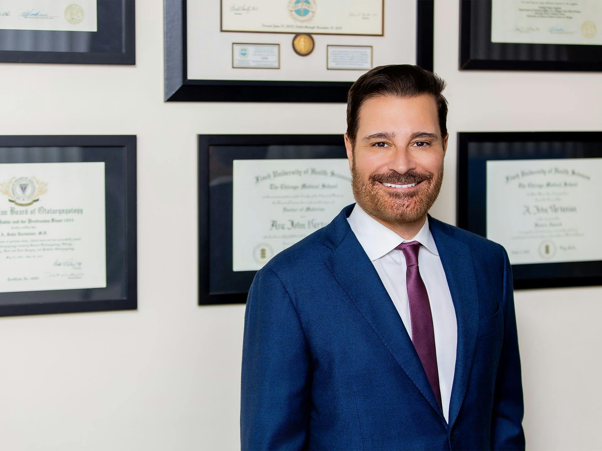 Dr. John Vartanian standing infront of his awards