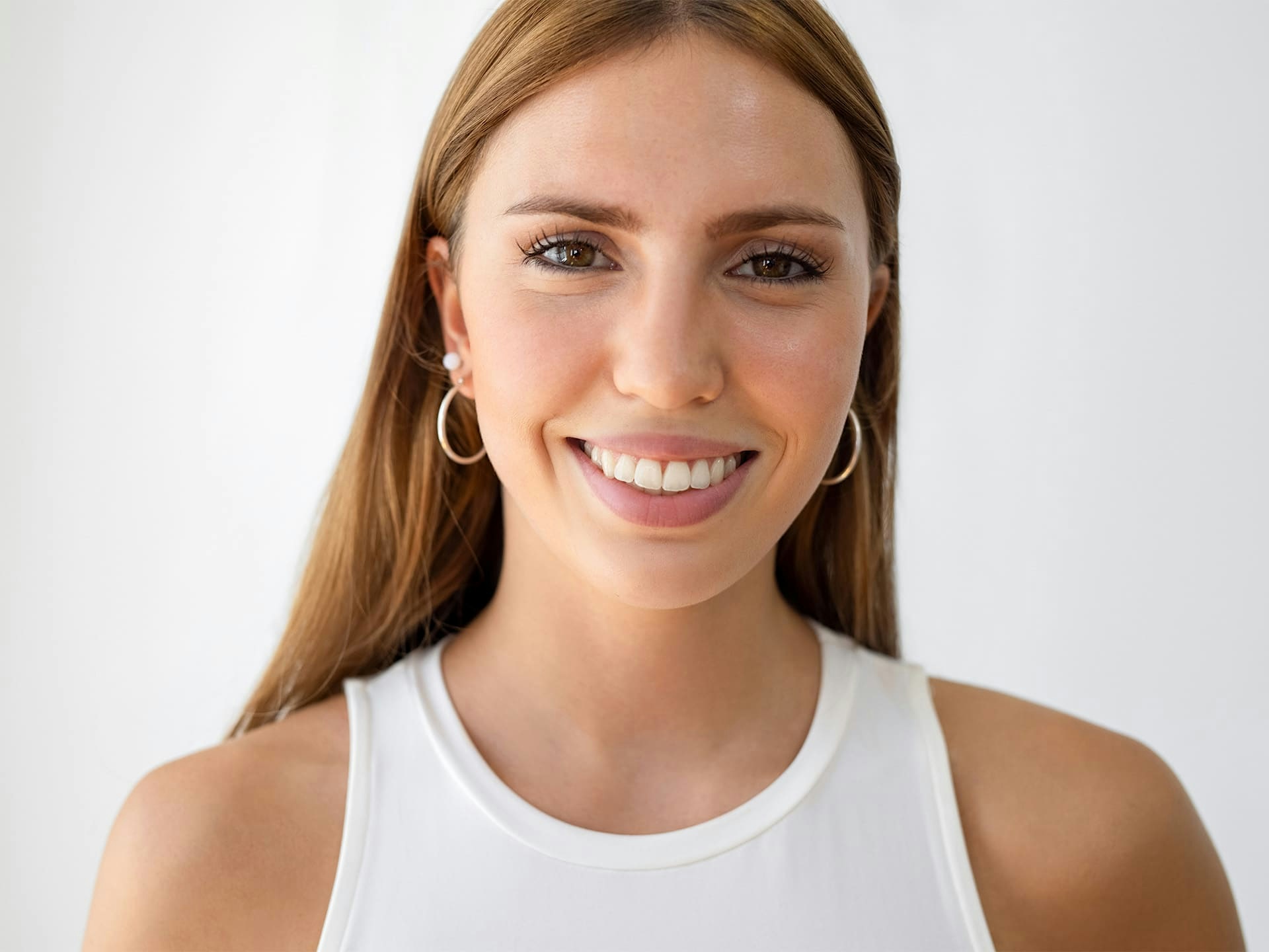 woman smiling forward in white tanktop
