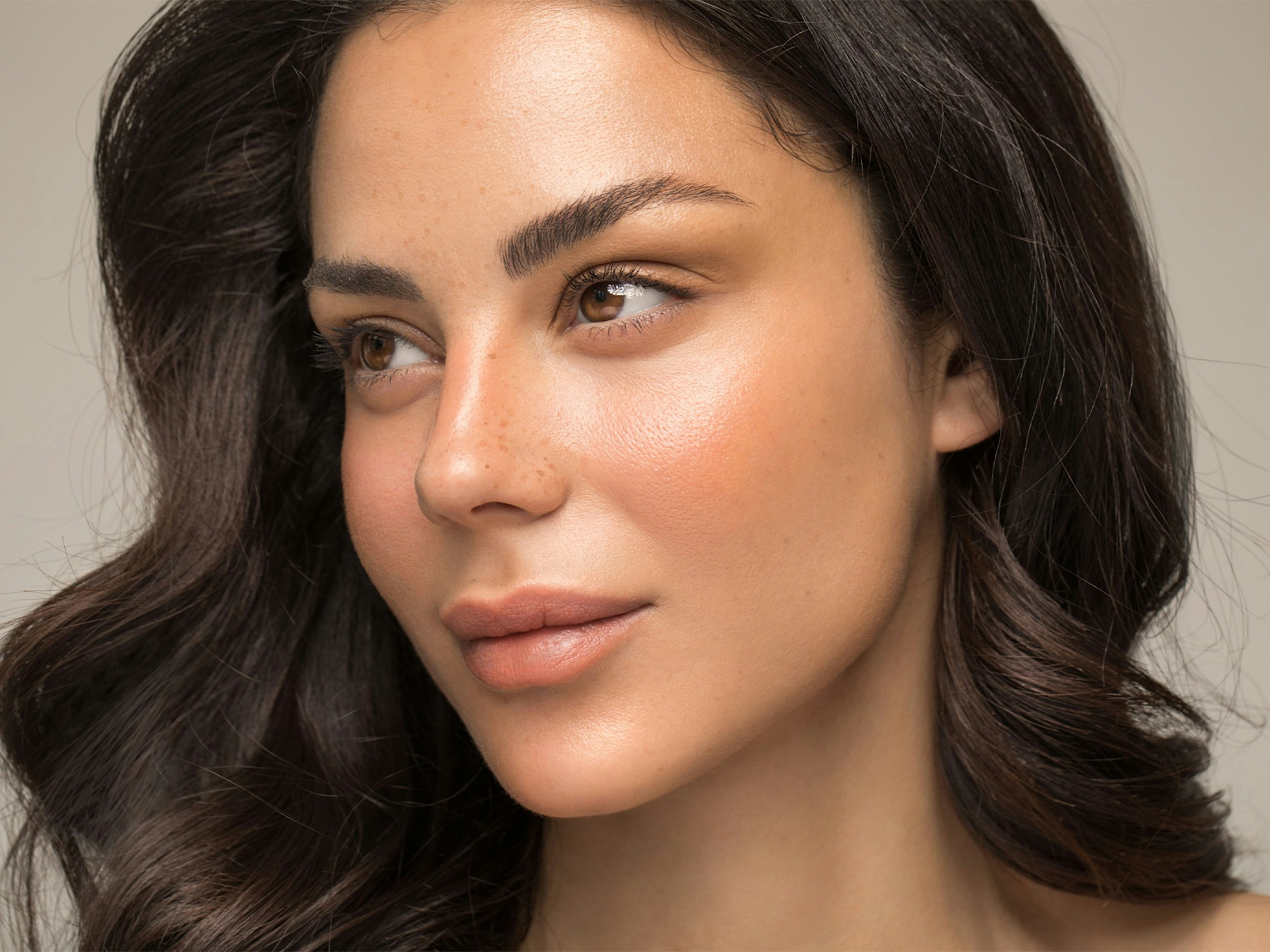woman with wavy brown hair looking to the left