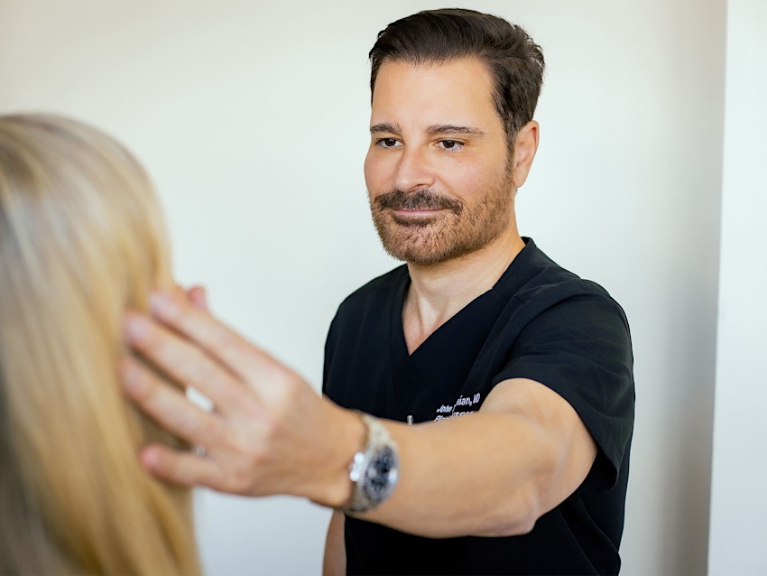 Dr. John Vartaian looking at female patient's face