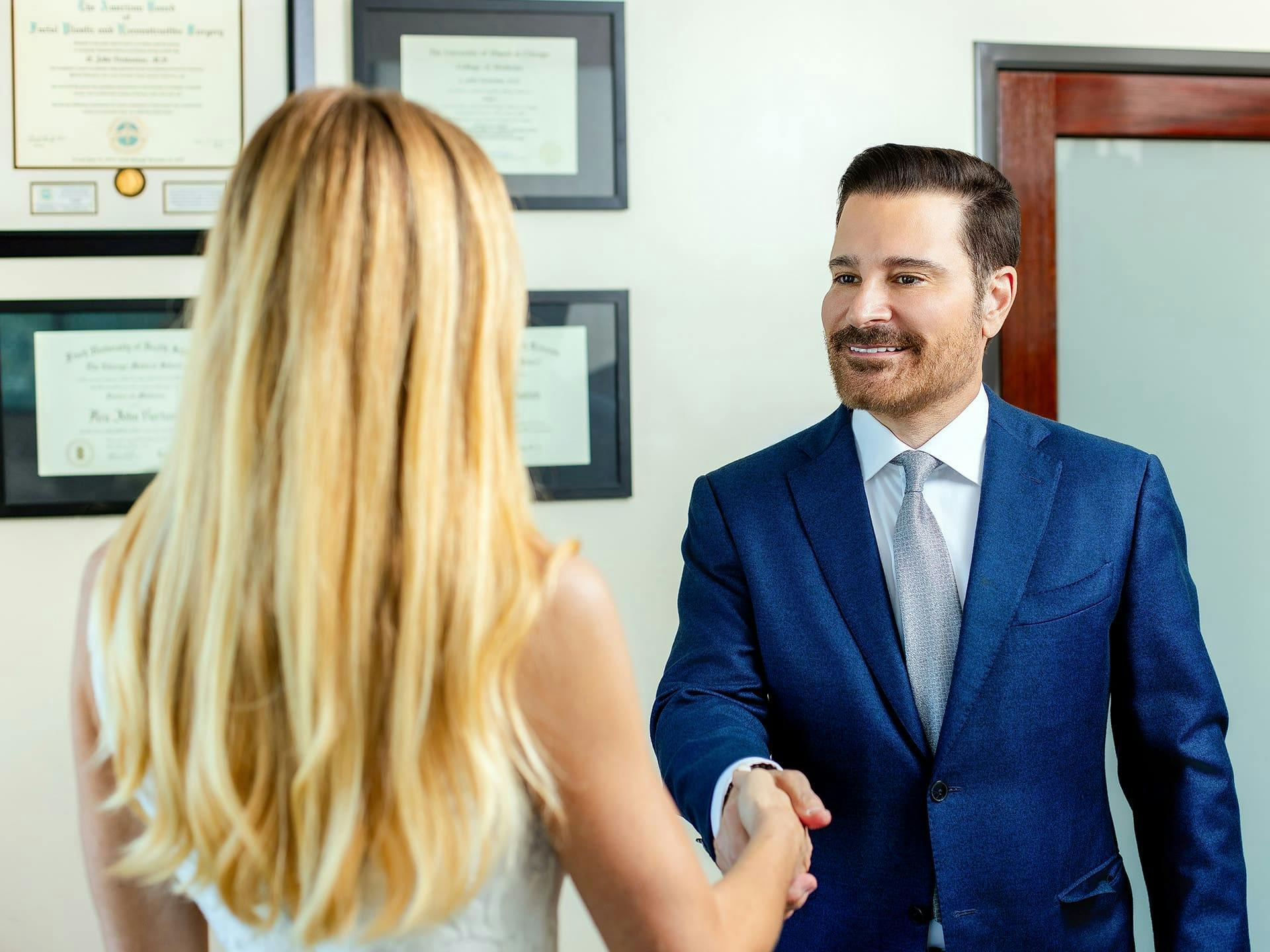 Dr. John Vartaian shaking hands with female patient