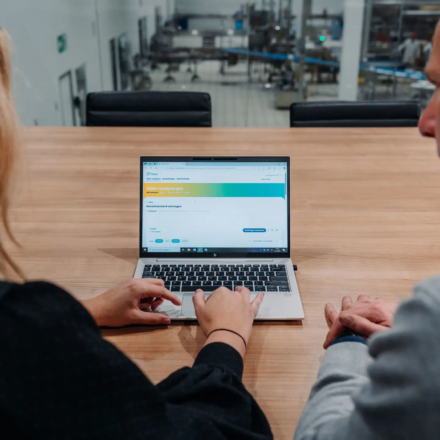 Twee mensen  werken achter een laptop