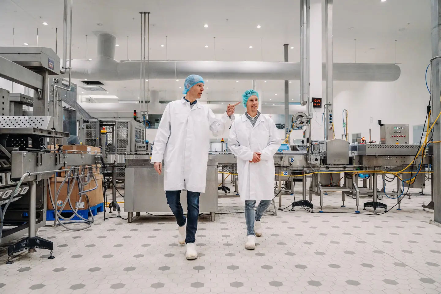 Twee mensen lopen door fabriek