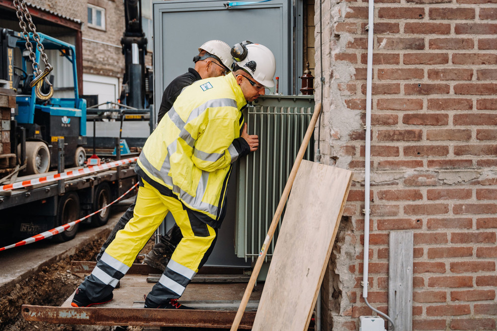 twee mannen aan het werk met een transformator