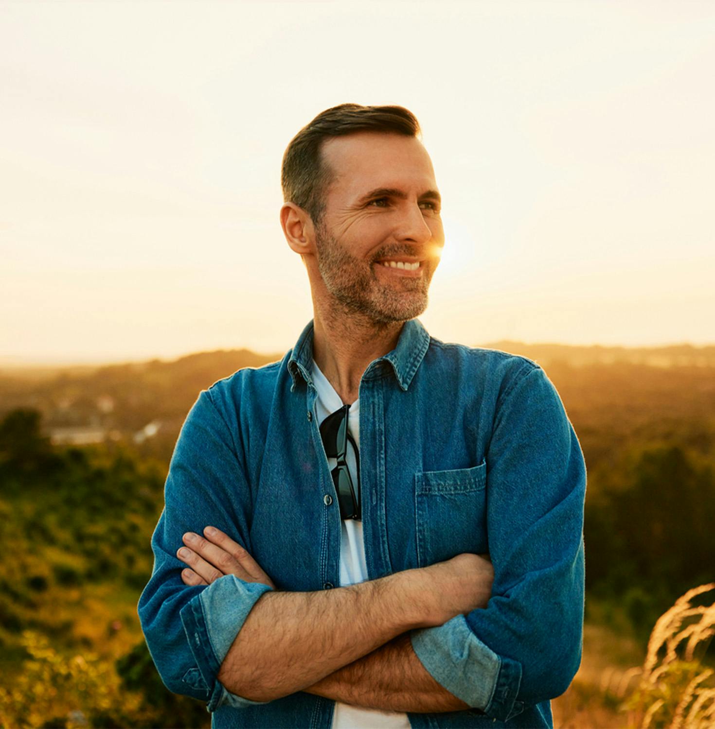 man smiling with arms crossed