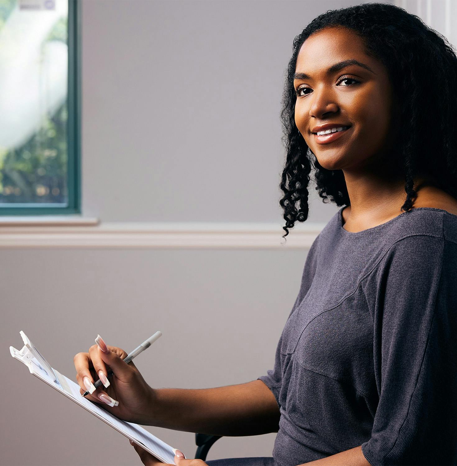 woman smiling signing clipboard