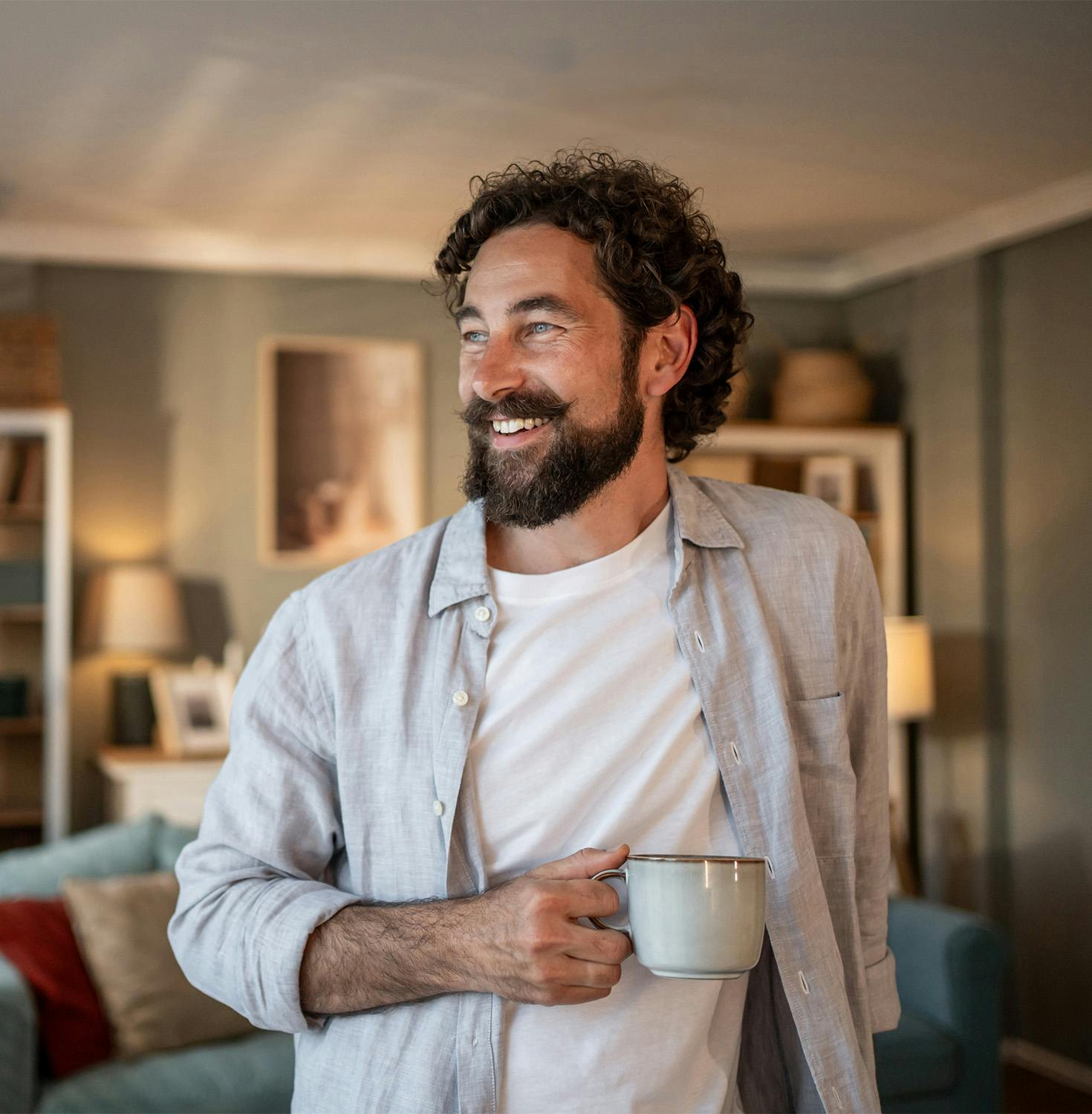 man smiling holding a mug